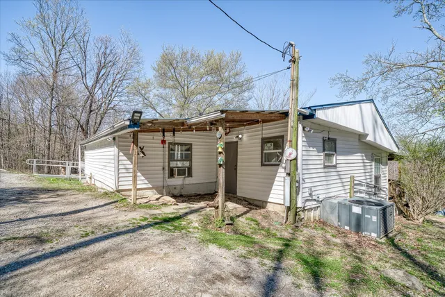 a view of a house with a yard and large tree