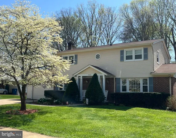 a front view of a house with a yard and trees
