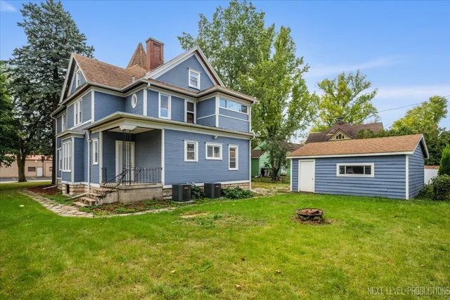a front view of a house with a yard and trees