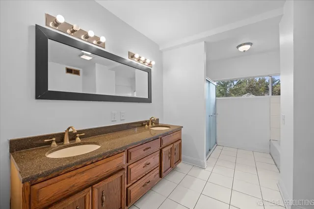 a bathroom with a granite countertop sink a mirror and vanity