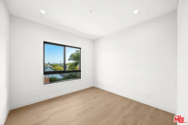 a view of a room with wooden floor and a window