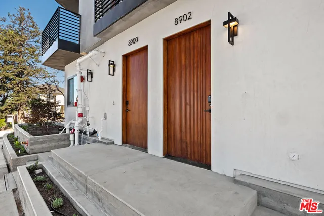 a view of a white building among the street with palm trees