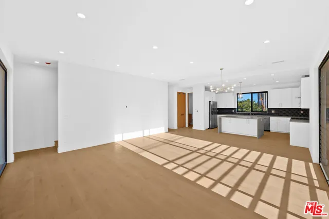 a large kitchen with kitchen island granite countertop a refrigerator and a sink