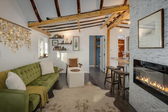 a living room with furniture a fireplace and kitchen view