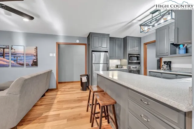 a large kitchen with stainless steel appliances kitchen island granite countertop a refrigerator and a sink