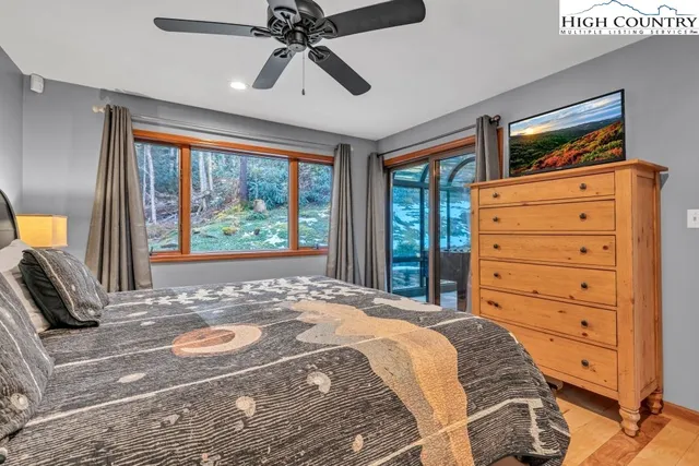 a bedroom with a bed a window and a flat screen tv