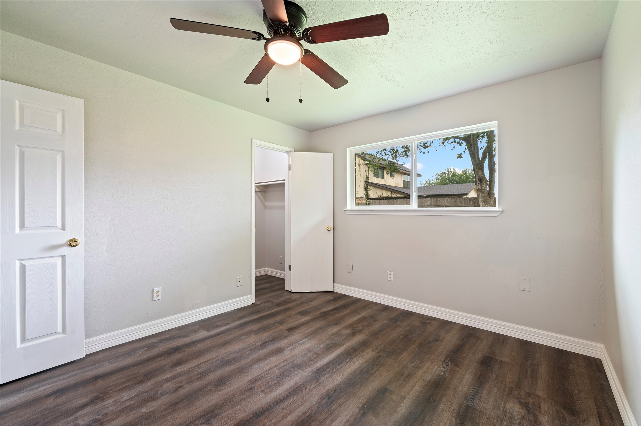 15050 Blueridge Road Missouri City, TX 77489 - Photo 19 of 30 an empty room with wooden floor ceiling fan and windows