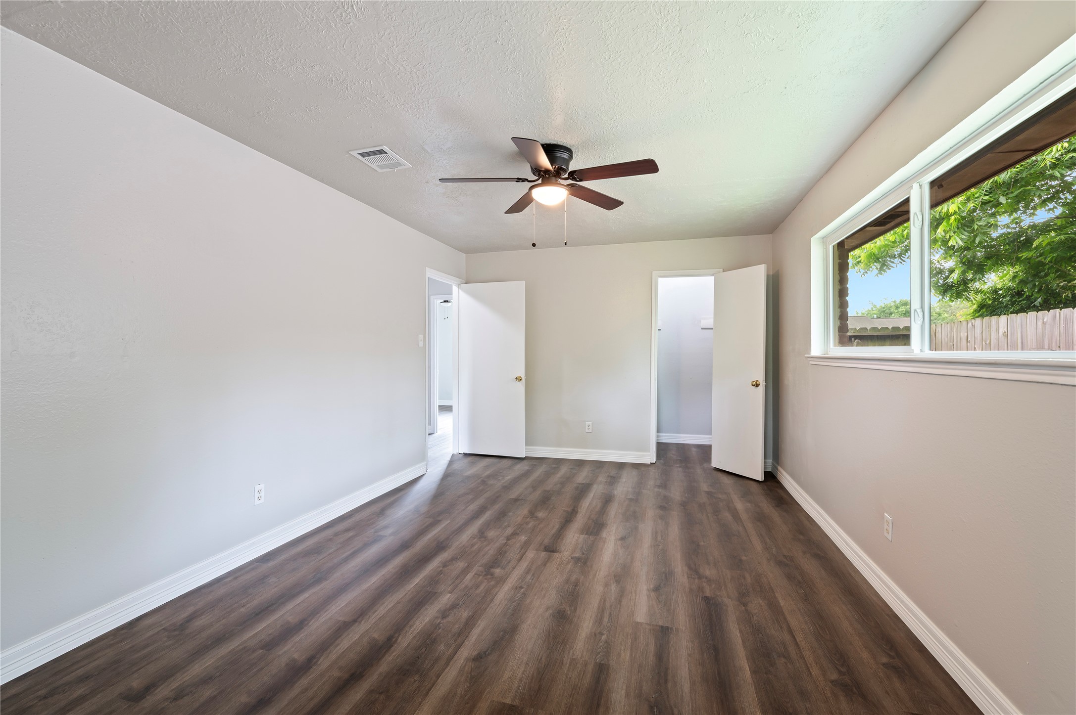 15050 Blueridge Road Missouri City, TX 77489 - Photo 20 of 30 an empty room with wooden floor and windows