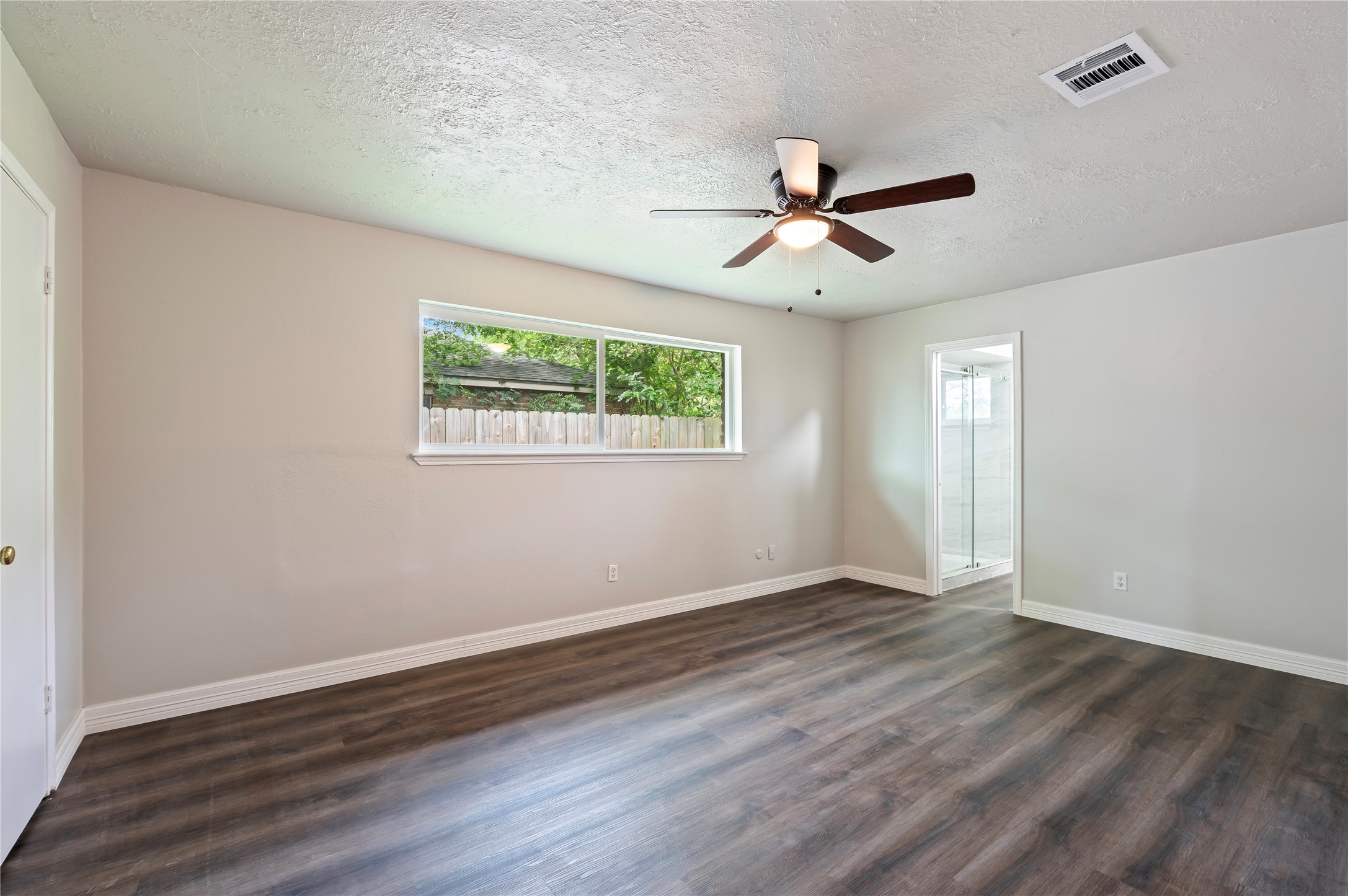 15050 Blueridge Road Missouri City, TX 77489 - Photo 22 of 30 an empty room with wooden floor ceiling fan and windows