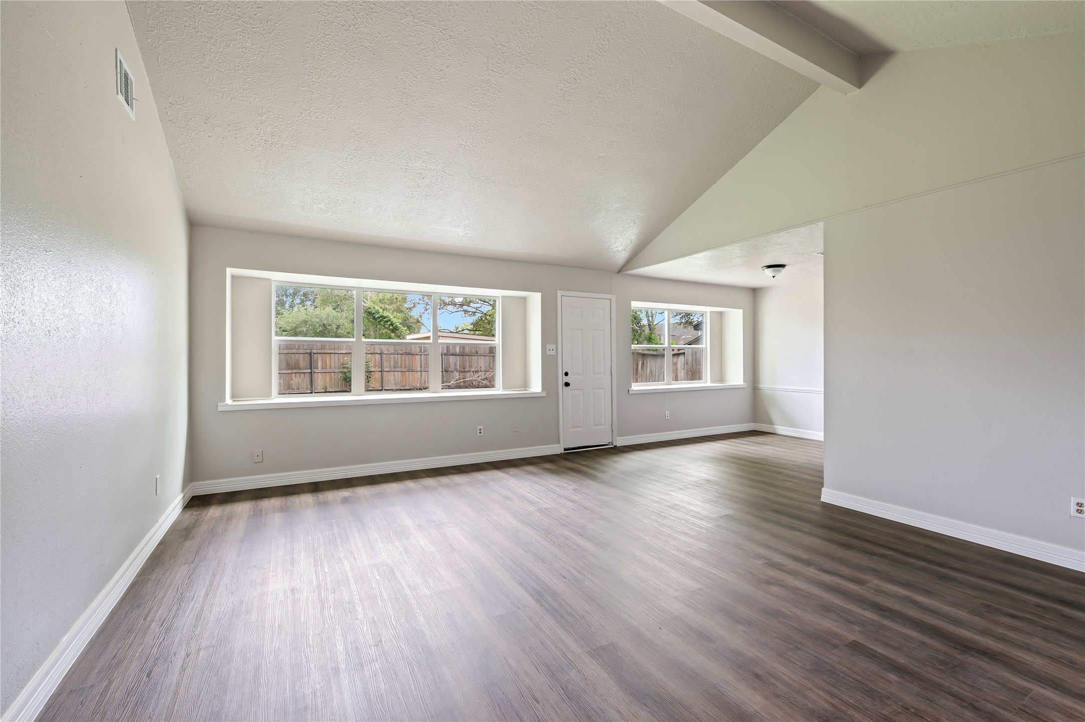 15050 Blueridge Road Missouri City, TX 77489 - Photo 5 of 30 an empty room with wooden floor and windows