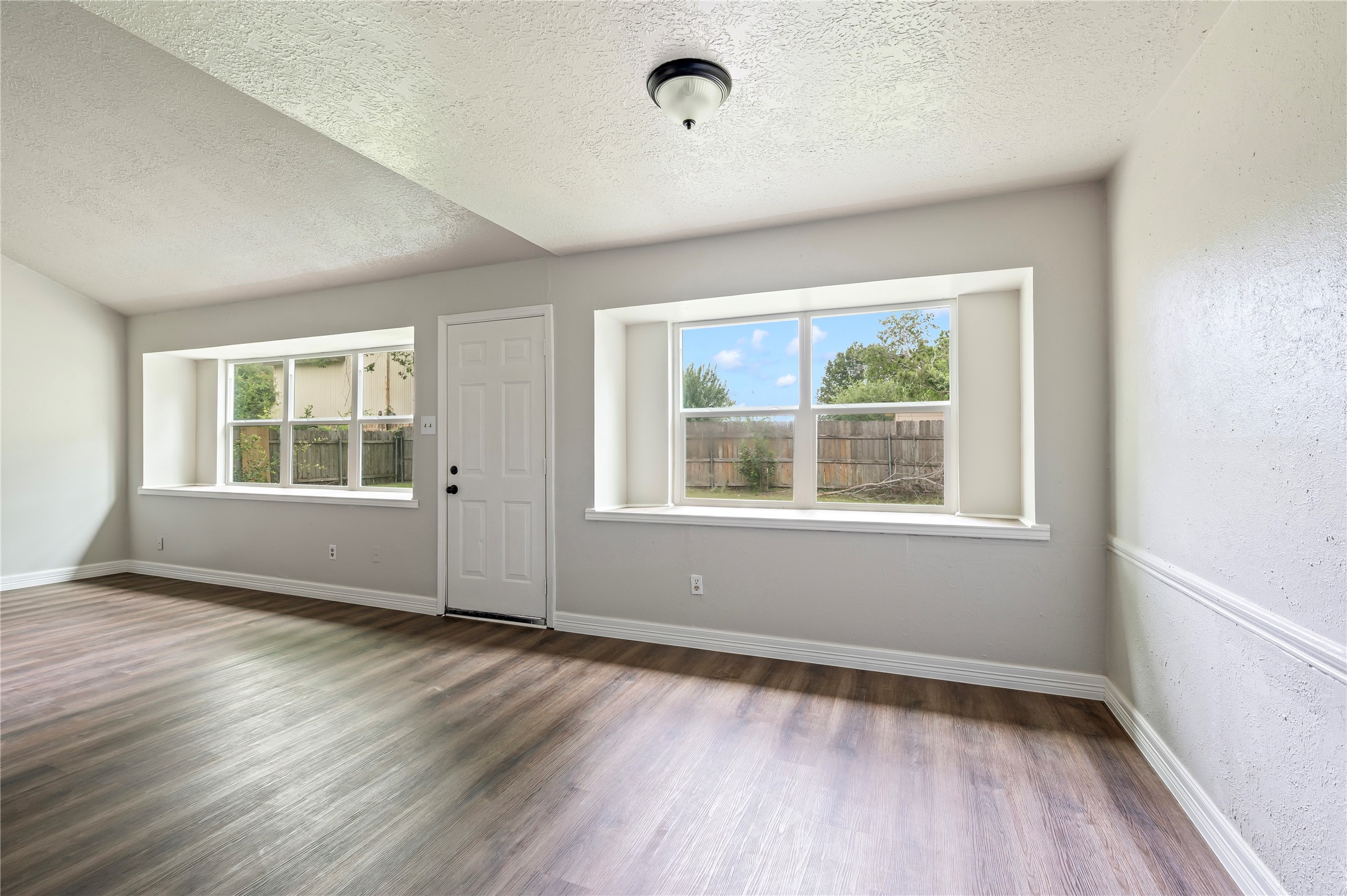 15050 Blueridge Road Missouri City, TX 77489 - Photo 8 of 30 an empty room with wooden floor and windows