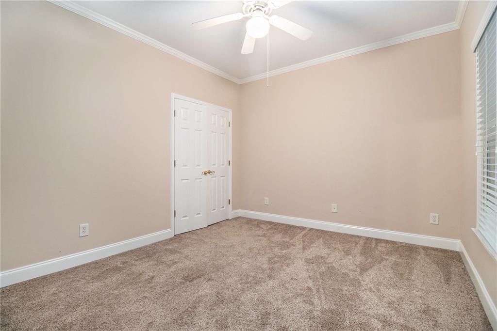 58 Poplar Circle Jasper, GA 30143 - Photo 21 of 31 an empty room with a ceiling fan and carpet