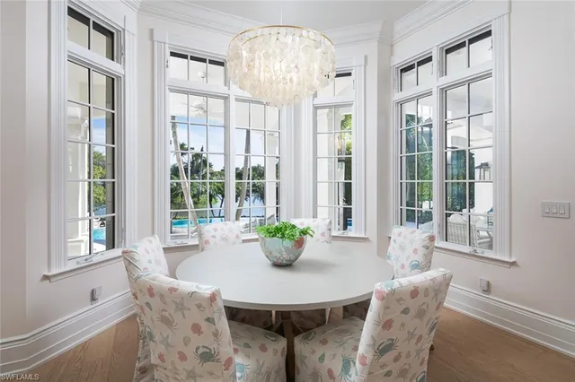 a dining room with furniture a chandelier and wooden floor