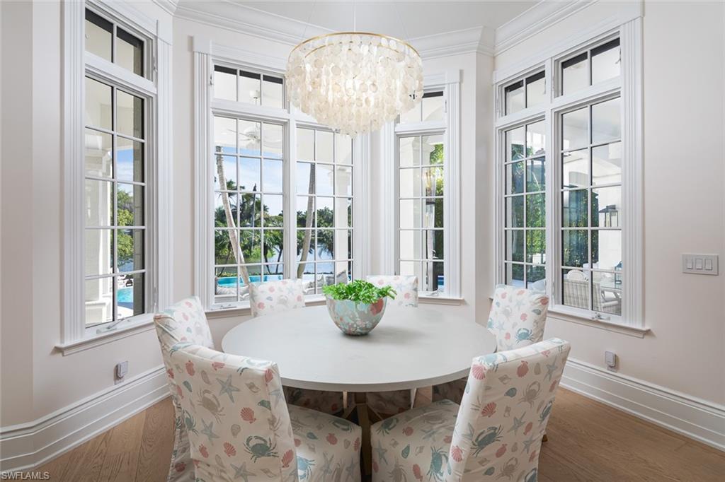 2595 Half Moon Walk Naples, FL 34102 - Photo 14 of 48 a dining room with furniture a chandelier and wooden floor