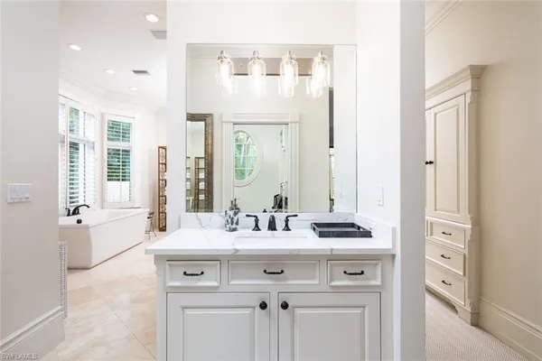 a bathroom with a sink vanity tub and a mirror