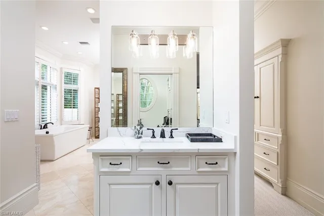 a bathroom with a sink vanity tub and a mirror