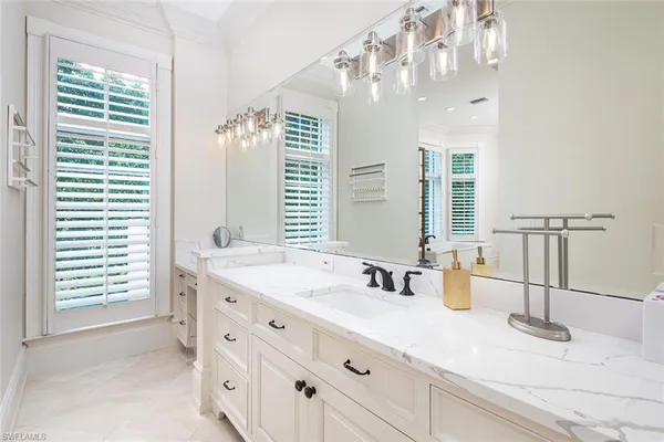 a bathroom with double vanity and a mirror