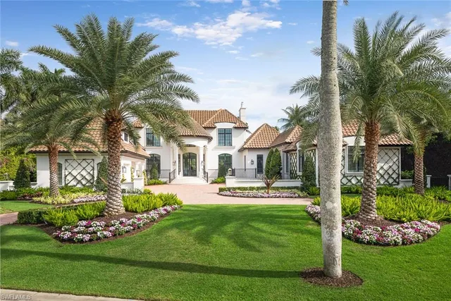 a front view of a house with a garden and trees