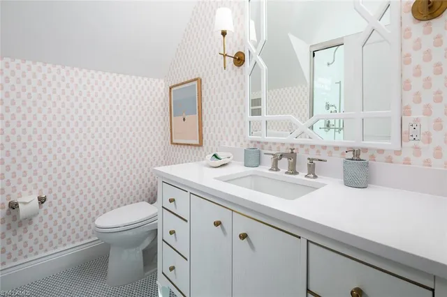 a bathroom with a granite countertop toilet a sink a mirror and a shower