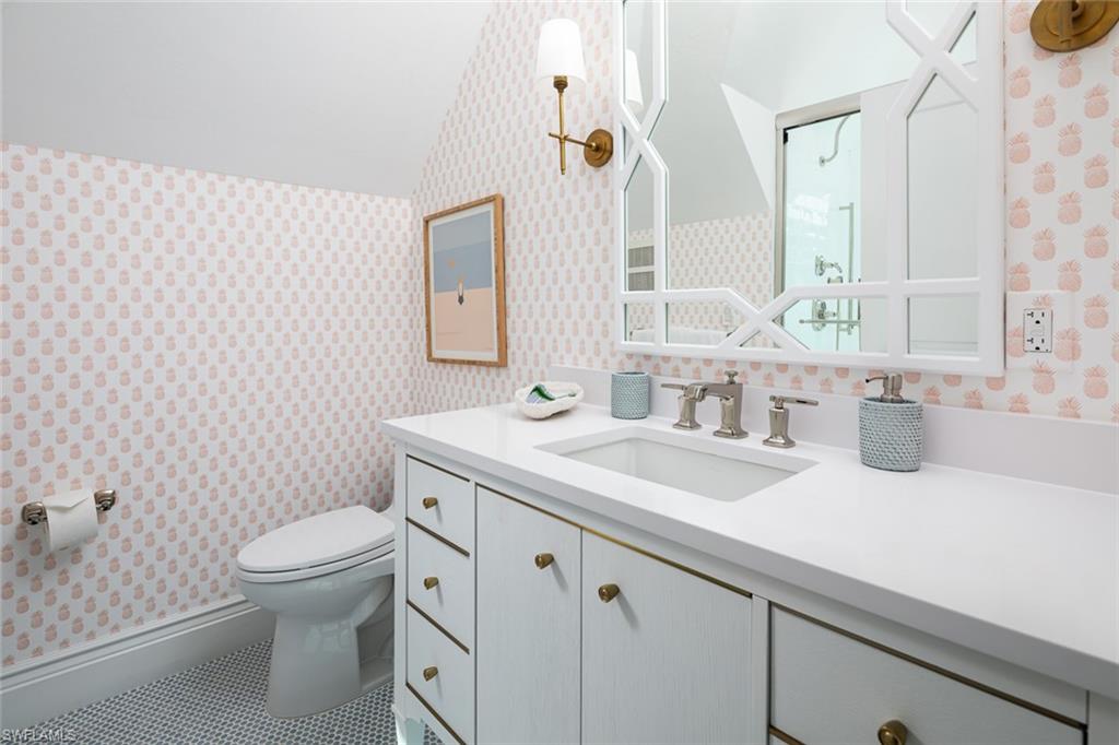 2595 Half Moon Walk Naples, FL 34102 - Photo 25 of 48 a bathroom with a granite countertop toilet a sink a mirror and a shower