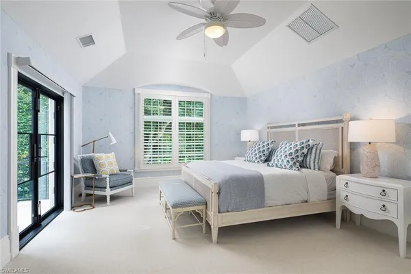 a bedroom with a bed chair and a large window