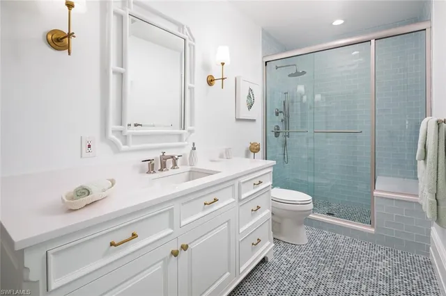a bathroom with a granite countertop sink toilet and shower