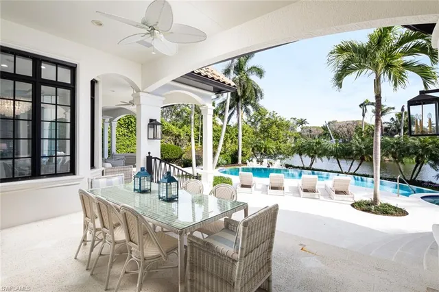a dining room with furniture a chandelier and a floor to ceiling window