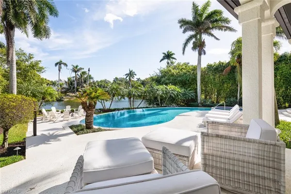 a view of backyard with swimming pool and outdoor seating