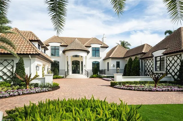 a front view of a house with a garden and plants