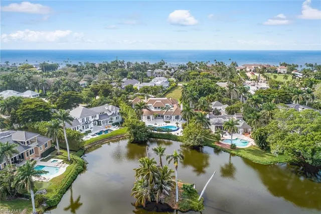an aerial view of residential houses with outdoor space and lake view