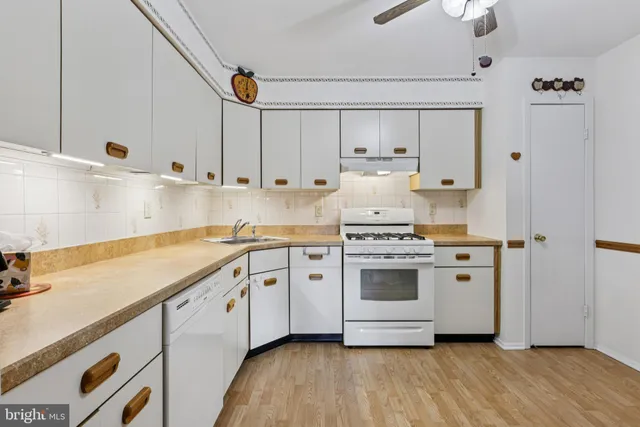 a kitchen with granite countertop white cabinets and white appliances