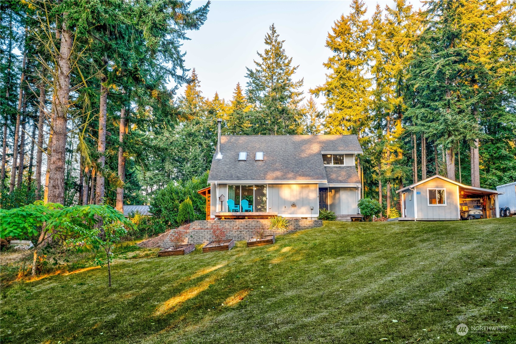 83-B Port Gardner Drive Hat Island, WA 98201 - Photo 2 of 33 a view of a house with a big yard and large trees