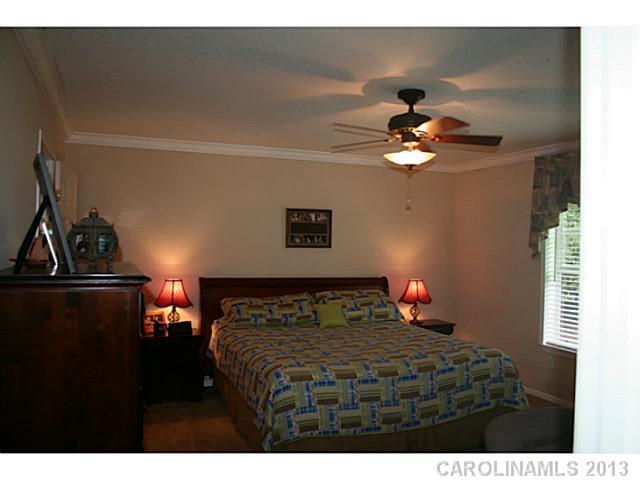 17300 Cool Springs Road Cleveland, NC 27013 - Photo 13 of 14 a bedroom with a bed and a chandelier