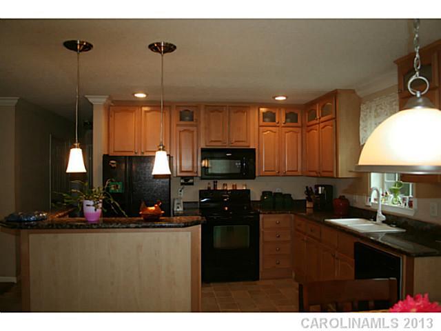 17300 Cool Springs Road Cleveland, NC 27013 - Photo 5 of 14 a kitchen with kitchen island granite countertop a sink stainless steel appliances and cabinets