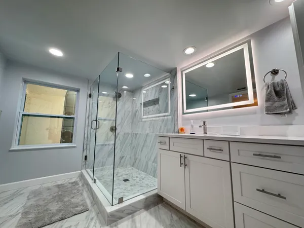 a bathroom with a shower sink and mirror