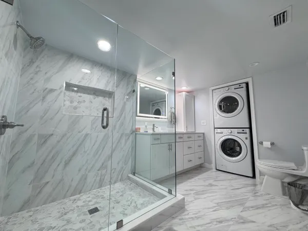 a bathroom with a granite countertop sink a mirror and shower