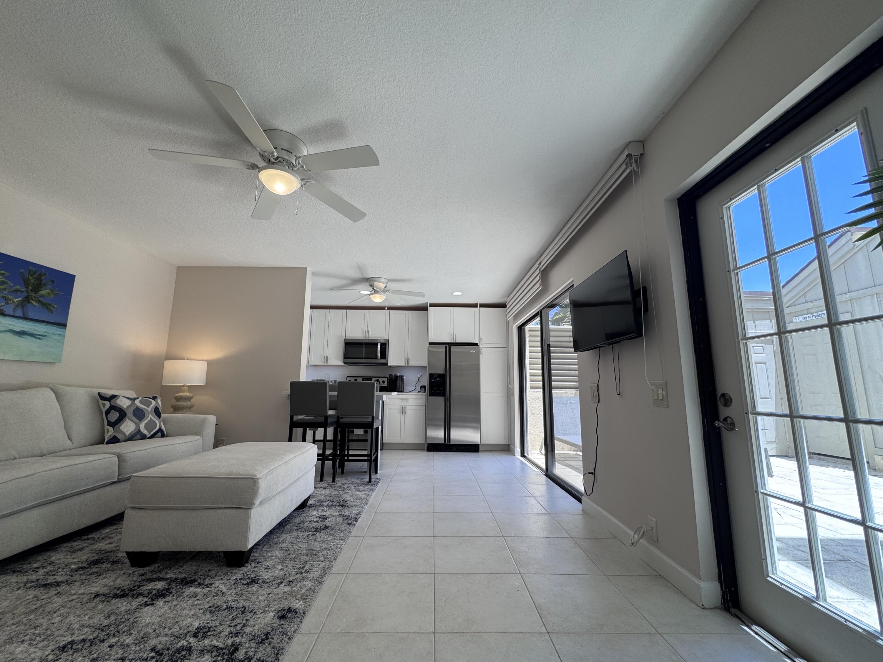 1605 Highway 1, Unit 1A Jupiter, FL 33477 - Photo 4 of 23 a living room with furniture a fireplace and a large window