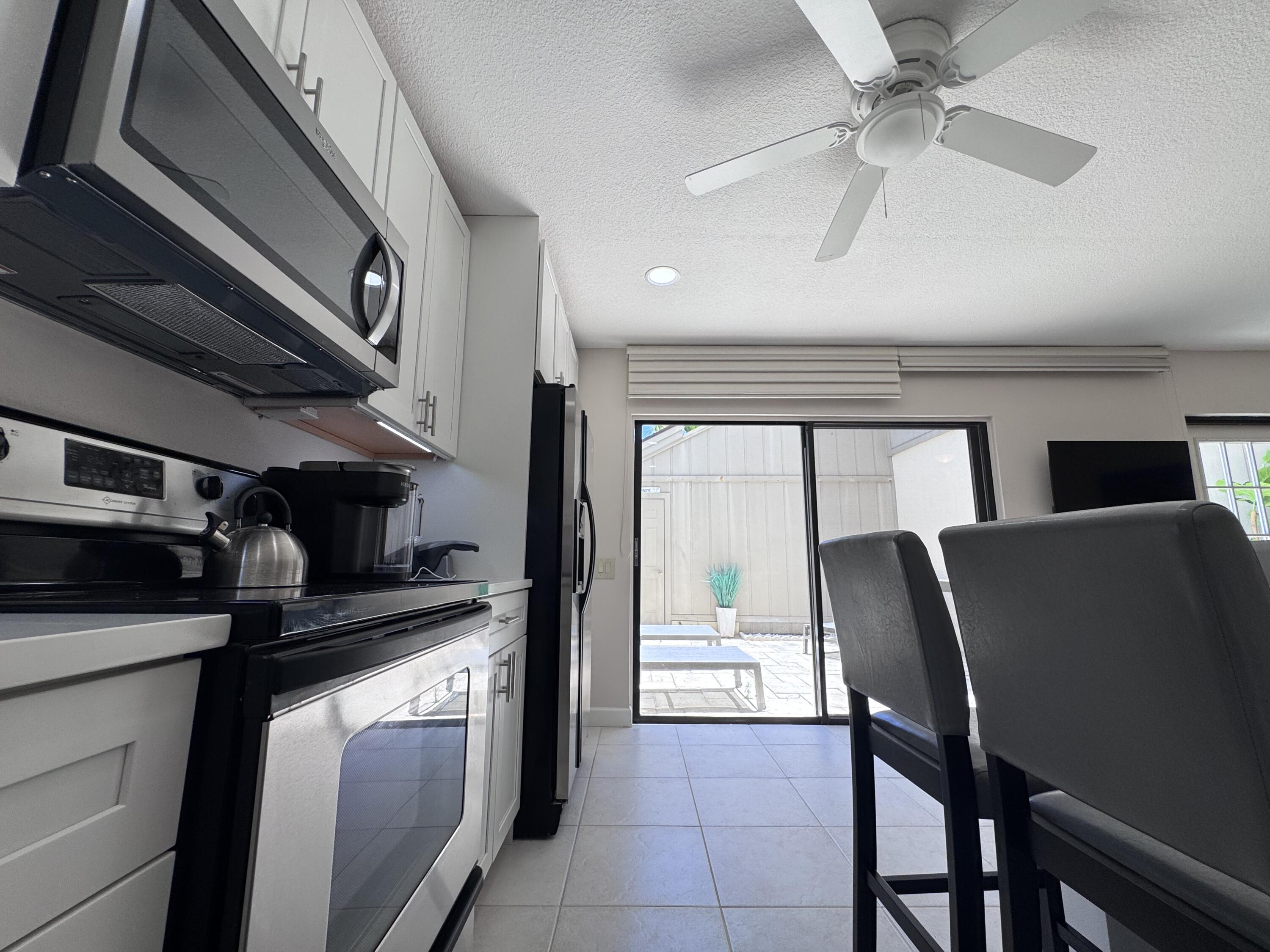 1605 Highway 1, Unit 1A Jupiter, FL 33477 - Photo 6 of 23 a kitchen with stainless steel appliances granite countertop a stove and a refrigerator