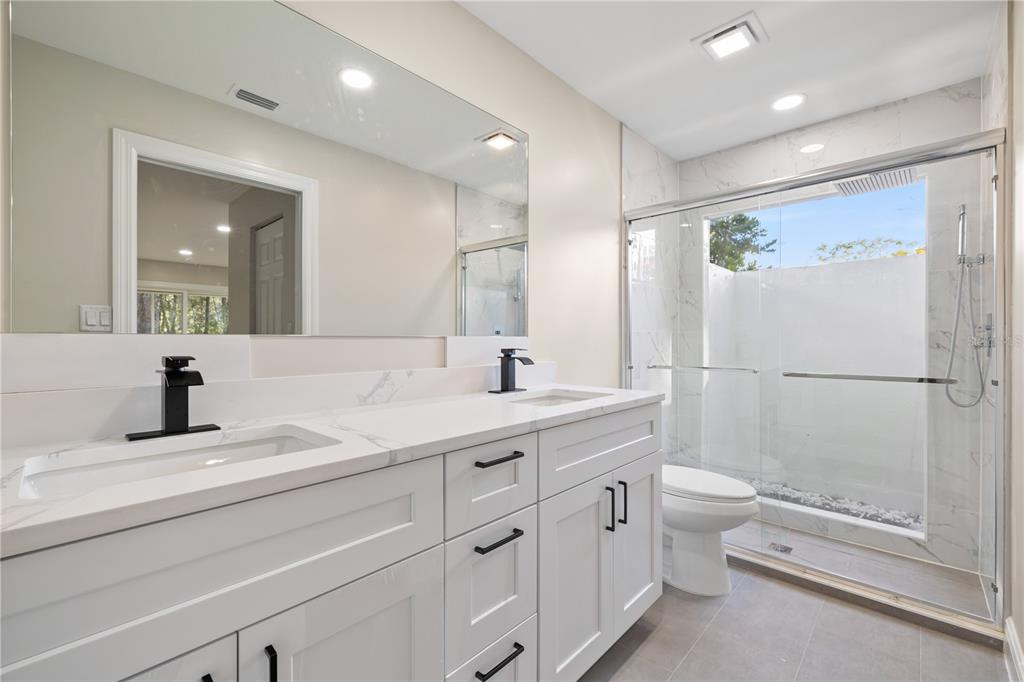 20045 Southwest 88th Place Road Dunnellon, FL 34431 - Photo 25 of 53 a bathroom with a granite countertop sink a toilet and a large mirror