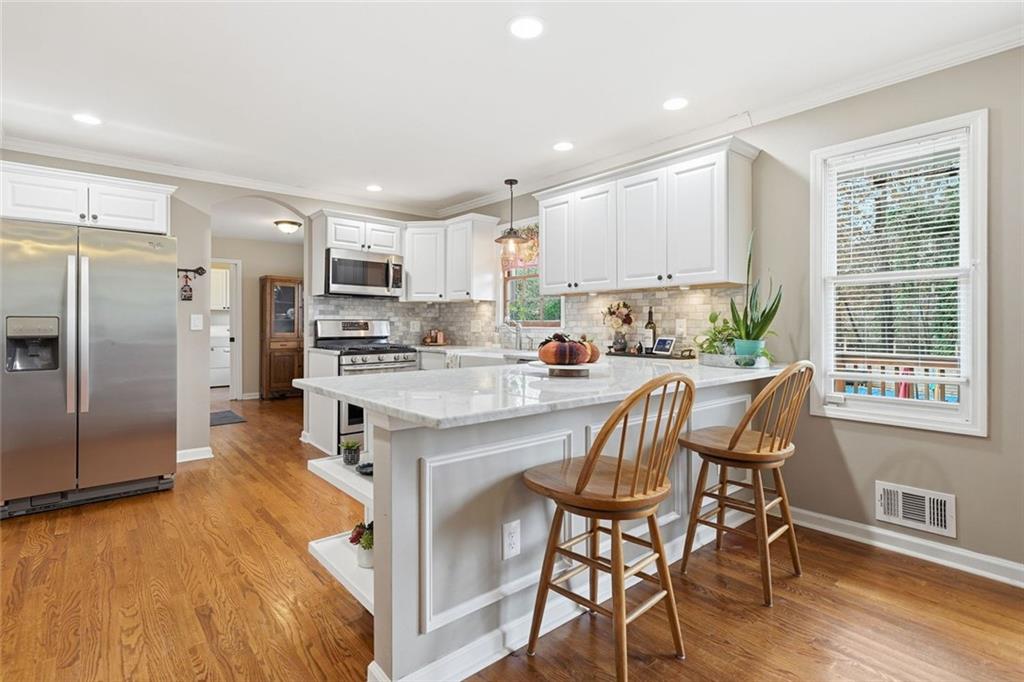 438 Mountainview Circle Canton, GA 30115 - Photo 14 of 41 a kitchen with stainless steel appliances granite countertop a refrigerator a stove a sink a dining table and chairs with wooden floor