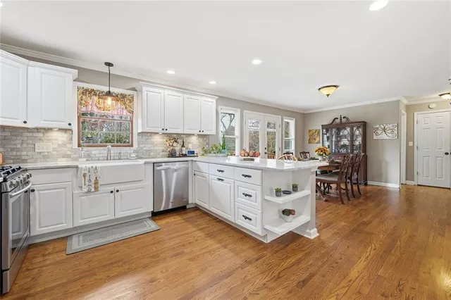 a kitchen with stainless steel appliances granite countertop a stove a sink and a microwave