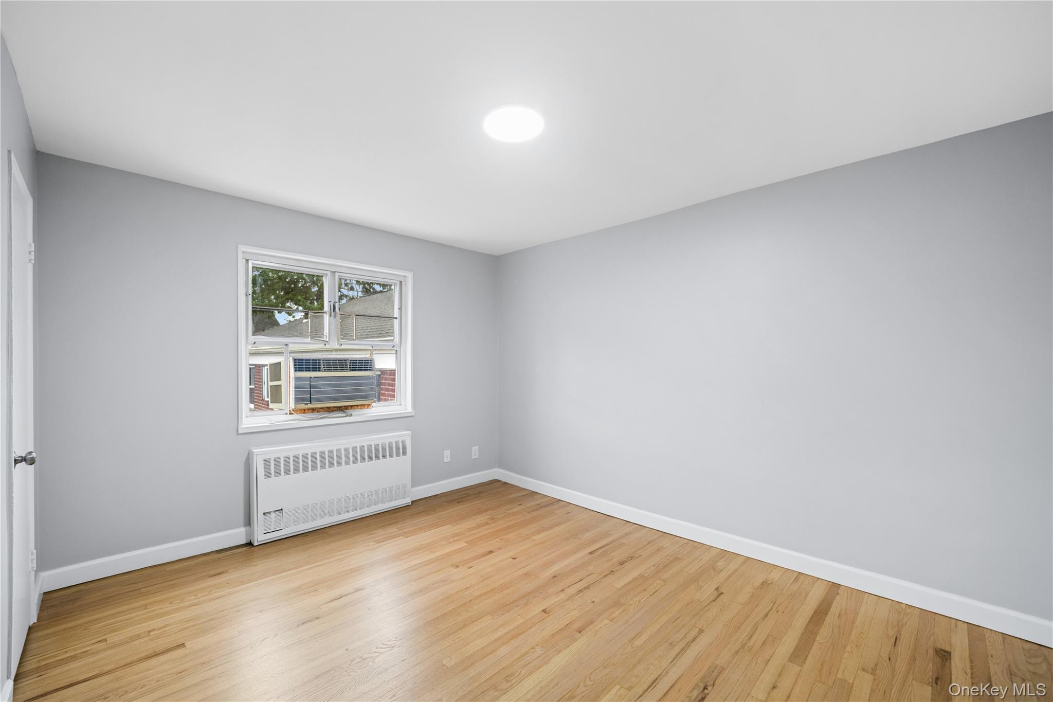 226-29 Manor Road, Unit 2 Queens, NY 11427 - Photo 11 of 17 Room with light gray walls and wood-finish flooring
