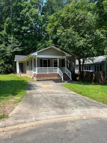 a front view of a house with a yard and trees