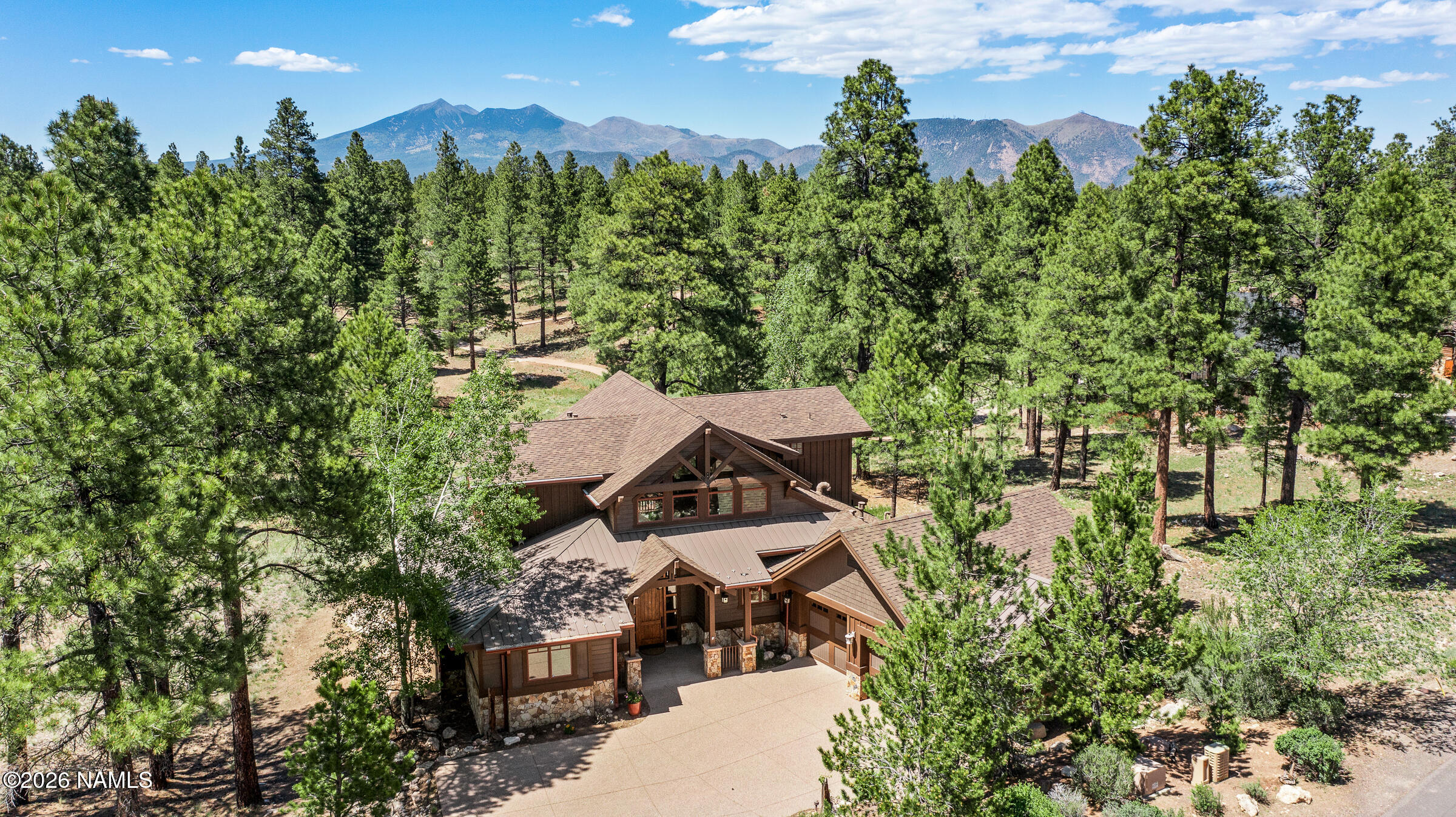 an aerial view of a house with a yard and trees