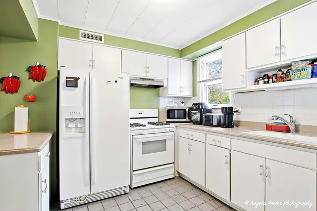 a kitchen with white cabinets and white appliances