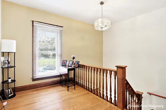 a view of a hallway with windows and chandelier