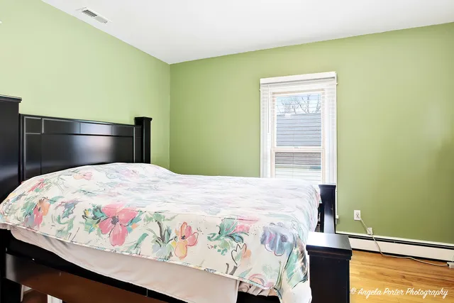 a bedroom with a bed and wooden floor