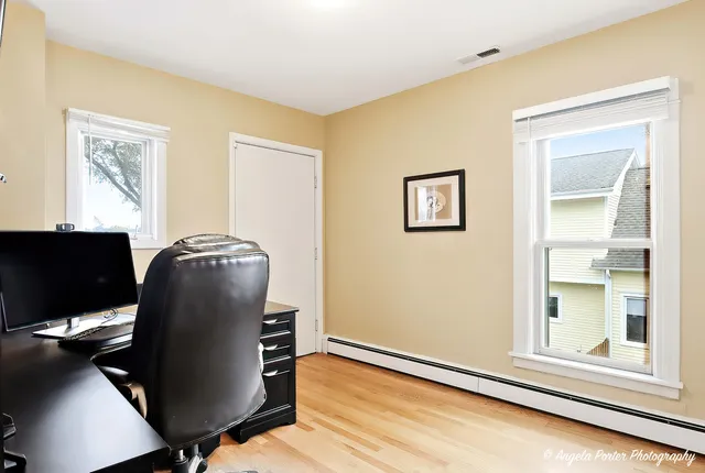a view of a workspace with furniture and a window