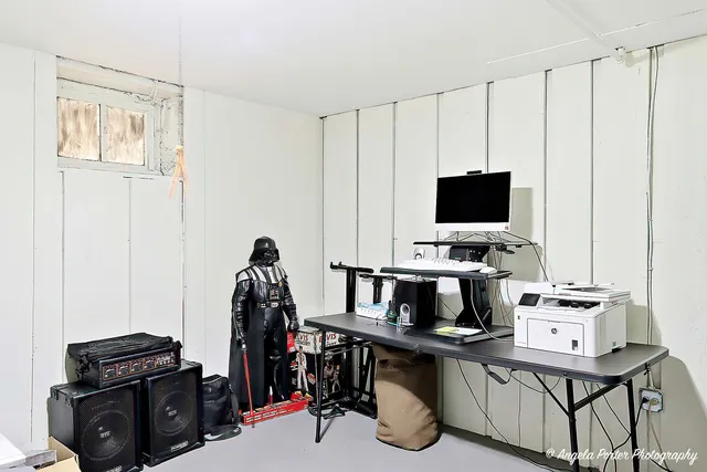 a view of a workspace with furniture and a window