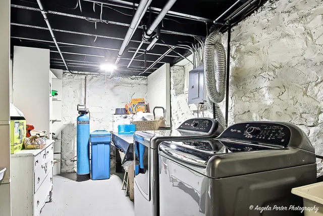 a utility room with dryer washer and stair